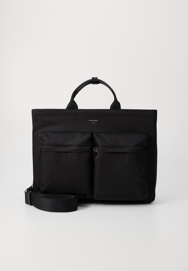 Sort nylon tote taske med to frontlomme med lynlås, dobbel toppehåndtag og en justerbar rem. Har en glat tekstur og minimal branding.