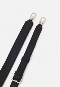 Correa de cuero negro con herrajes de metal plateado, que presenta una textura suave, una hebilla y dos enganches en cada extremo.