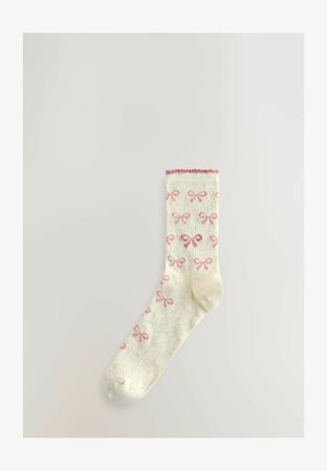 Knee-high čarape u krem boji s uzorkom ružičastih mašnica, rebrasti rub i mekana tekstura. Lagan i prozračan dizajn.