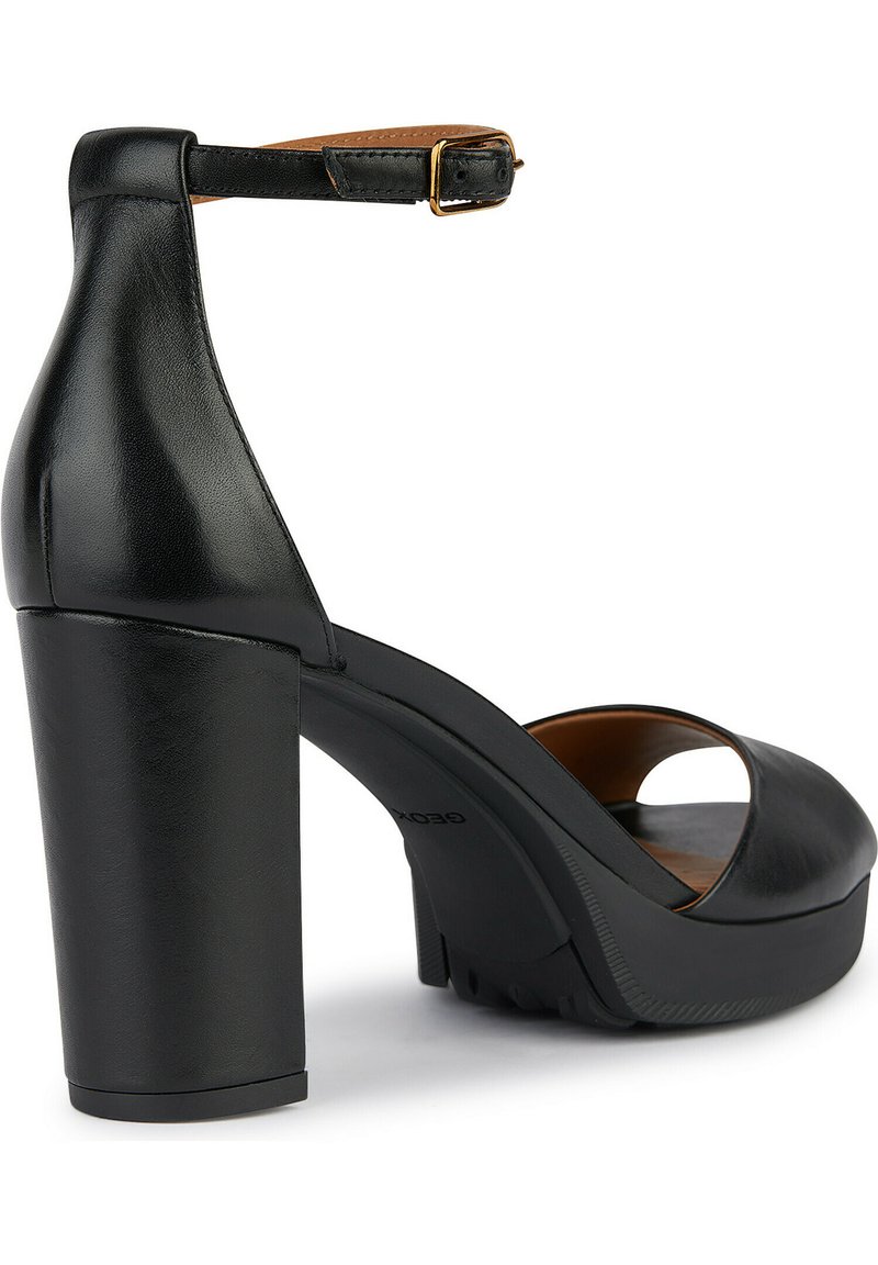 Sandali neri in pelle con tacco alto, dotati di un cinturino alla caviglia. Presentano una punta aperta e una texture liscia. Caratterizzati da un discreto dettaglio del logo.