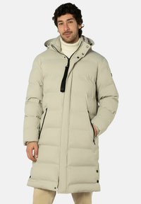 Gepolsterter langer Mantel in Hellbeige mit Reißverschluss, Kapuze und schwarzen Akzenten. Verfügt über Seitentaschen und sichtbare Nahtdetails.