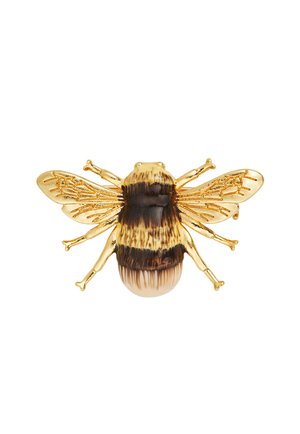 Złota broszka w kształcie pszczoły z emaliowanymi, półprzezroczystymi, fakturowanymi skrzydłami oraz ciałem w paski w kolorze żółtym i ciemnobrązowym na białym tle.