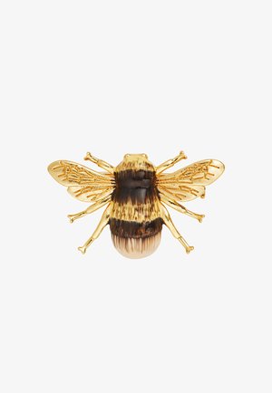 Broche de abeja de oro y esmalte con alas translúcidas texturizadas y cuerpo a rayas en amarillo y marrón oscuro sobre fondo blanco.