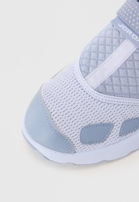Light blue sneaker featuring mesh fabric and smooth accents. Rounded toe with stitching details, and a rubber sole. Subtle texture pattern.
