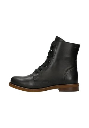 Stivale alla caviglia in pelle nera con punta tonda, lacci frontali, occhielli in metallo e suola marrone a contrasto. Texture liscia e accenti minimi.
