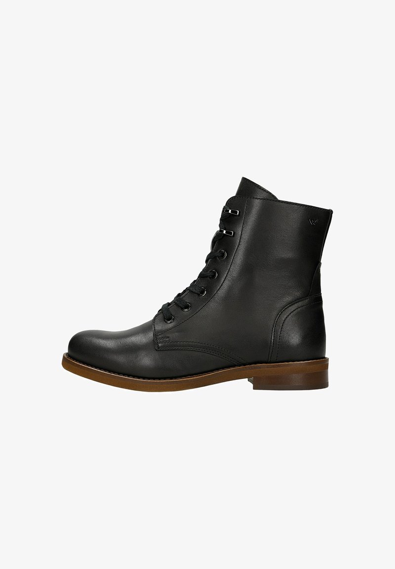 Černá kožená kotníková bota s kulatou špičkou, šněrováním v přední části, kovovými očky a kontrastní hnědou podrážkou. Hladký povrch a minimální akcenty.