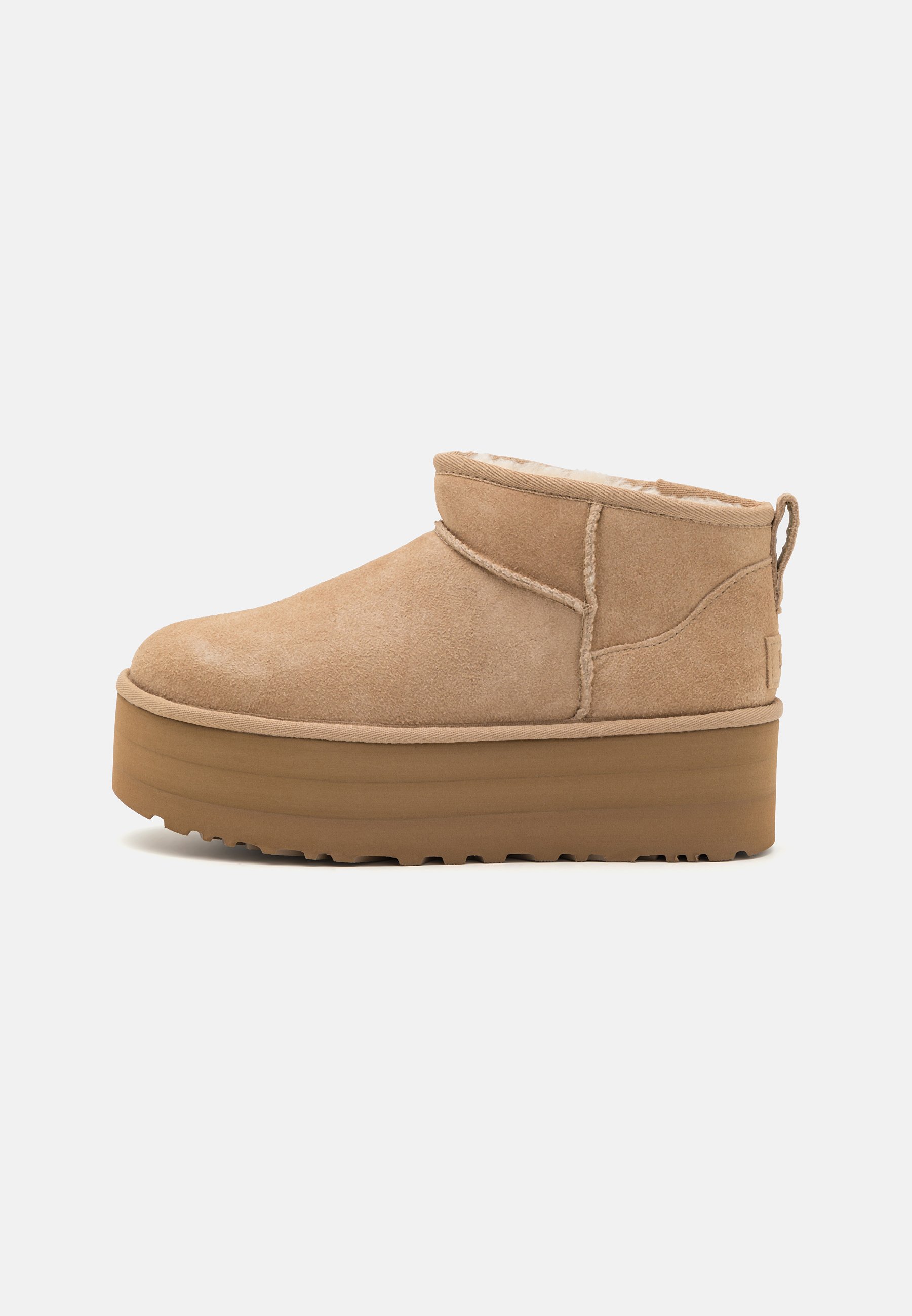 Beige Wildleder-Ankle Boots mit einem weichen Innenfutter, ausgestattet mit einer Plateausohle und einer Zuglasche hinten für einen einfachen Einstieg. Strukturiertes Gummiprofil.