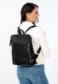 Black nylon backpack with a sleek design, featuring zippers, adjustable straps, and a top handle for versatility. Smooth texture.