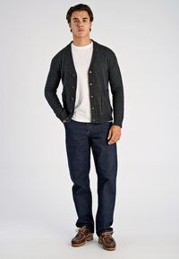 Tummanharmaa neuletakki napituksella, teksturoitu neulos, kaksi etutaskua; puettu valkoisen t-paidan ja tummansinisten farkkujen päälle, yhdistetty ruskeisiin kenkiin.