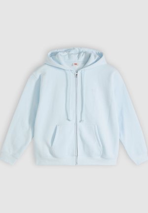 Lyseblå hettejakke med glidelås laget av mykt stoff, med en frontlomme, snøring i hetten, og et subtilt logo-detalj på brystet.