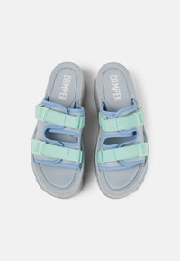 Sandales bleu avec deux brides réglables vert menthe, semelles intérieures rembourrées et semelles en caoutchouc texturé. Présente le logo "Camper" sur la semelle.