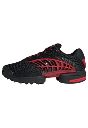 Zapatilla deportiva negra con soporte lateral tipo jaula en rojo, parte superior de malla, suela negra con detalles en rojo y cierre de cordones.