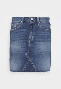 Jeanskjol i mörkblått med en lätt blekning. Har dragkedja, knappstängning och en asymmetrisk fåll med ett unikt sömnadsmönster.