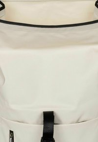 Zaino impermeabile di colore chiaro con chiusura a rotolo, dettagli neri e tracolla regolabile. Include una tasca frontale con cerniera.