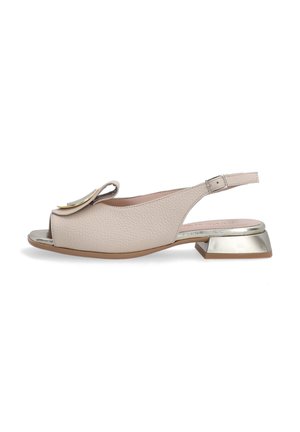 Beige leather slingback sandal with open toe, featuring a layered floral accent and a metallic block heel. Textured surface and adjustable strap.