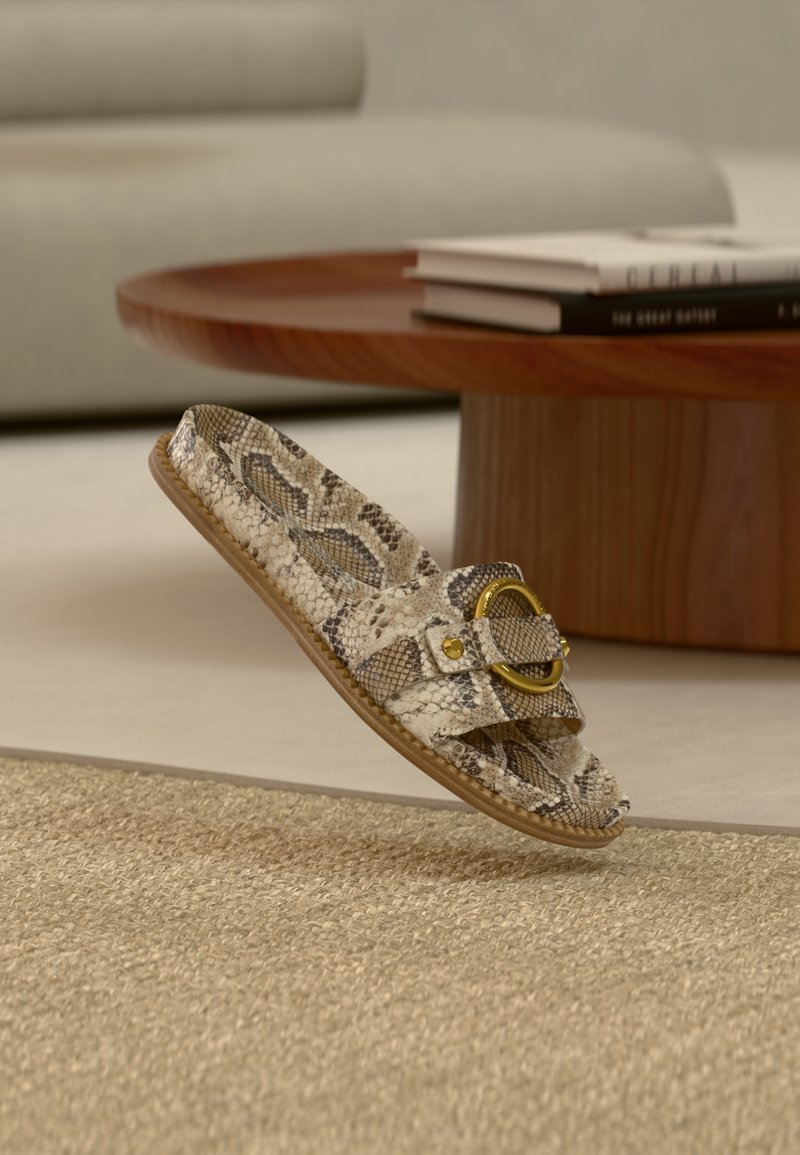 Σανδάλι τύπου slide με σχέδιο φολιδωτού δέρματος, δύο λουριά και χρυσή κυκλική αγκράφα. Επίπεδη σόλα και υφή στο πέλμα σε ουδέτερους τόνους.