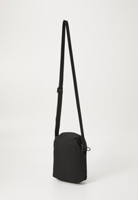 Schwarze Stoff-Crossbody-Tasche in rechteckiger Form, mit verstellbarem Gurt und Reißverschluss. Angenehme Textur mit minimalistischem Design.