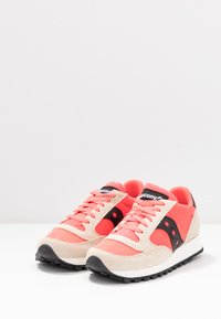 Korallenfarbene und beige Sportschuhe mit einem strukturierten Obermaterial, schwarzen Akzenten und einer Gummisohle. Verfügt über einen gepolsterten Schaft und Schnürsenkel.