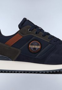 Sneaker blu navy con materiali in suede e tessuto, striscia di accento marrone, suola in gomma e patch logo circolare.