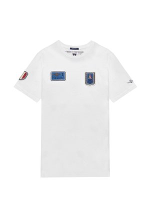 T-shirt bianca in cotone a maniche corte, dotata di toppe ricamate blu: "1 LEADER" e altri design su entrambe le maniche.