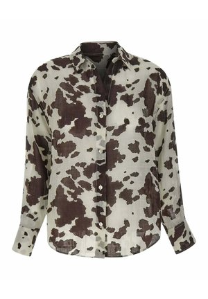 Chemise à manches longues boutonnée avec motif vache marron et blanc, col pointu et manches à poignets.