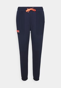 Marineblaue Jogginghose aus weichem Stoff, mit orangefarbenem Kordelzug, Seitentaschen, elastischen Bündchen und einem kleinen Etikett am linken Bein.