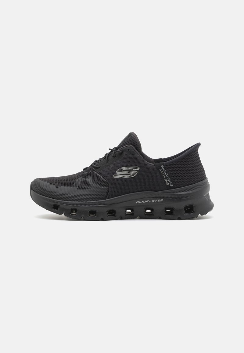 Chaussure de sport noire Skechers avec dessus en mesh, lacets à l’avant et semelle ventilée avec inscriptions "Glide-Step" et "Slip-Ins" sur les côtés.