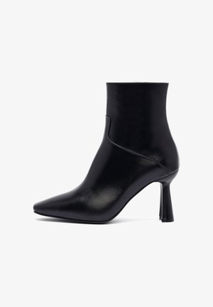 Stivaletto nero alla caviglia in pelle liscia, con punta affusolata e tacco alto conico, dotato di dettagli di cucitura minimi sui lati.
