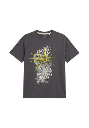Ciemnoszary T-shirt z krótkim rękawem z żółtym wybuchem gwiazdy nad białym odciskiem palca i tekstem "Timeless Tales" oraz mniejszym pismem poniżej.