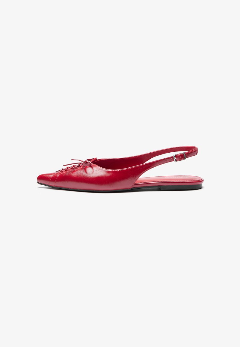 Punainen nahkainen slingback-mokkasiini, jossa on teräväkärkinen muotoilu ja koristeellinen nauhakiinnitys edessä. Kenkässä on ohut nilkkaremmi ja tasapohja.