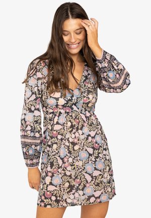 Robe florale avec un fond noir, ornée de fleurs roses et bleues. Décolleté en V, taille froncée et manches longues avec des poignets à motif.