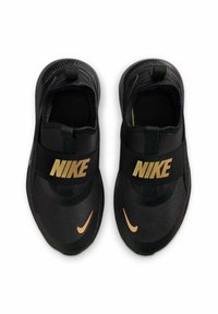 Zapatillas negras de Nike con tejido texturizado, correas elásticas y logo dorado. El diseño tipo slip-on presenta una puntera redondeada y suela negra.