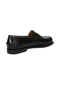 Mocassino in pelle nera con punta cucita, tacco basso e design slip-on, mostrato di lato su uno sfondo bianco.