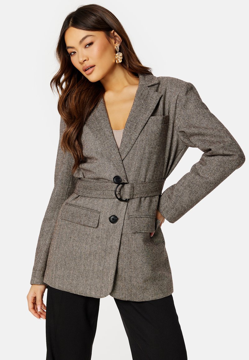 Blazer a motivo pied-de-poule in marrone e grigio, con cintura, due tasche frontali, rever a punta e chiusura con bottoni.