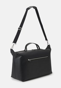 Musta nahkainen laukku, jossa on teksturoitu pinta, vetoketjukiinnitys, hopeiset yksityiskohdat, lyhyet kahvat ja säädettävä hihna. Etupuolella vetoketjutasku.