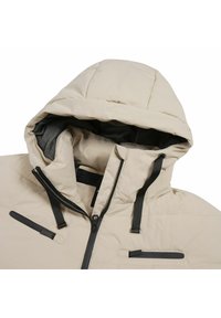 Béžová prošívaná bunda se zipem v přední části a kapucí. Obsahuje černé zipy a akcenty, strukturovanou vnitřní podšívku a dvě náprsní kapsy.