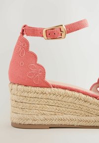 Sandalo espadrilla con zeppa in tessuto rosa, ricamo floreale, cinturino alla caviglia, fibbia dorata e suola piattaforma in juta intrecciata.