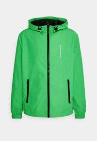 Groene capuchonjack gemaakt van lichtgewicht materiaal. Voorzien van een volledige rits, zwarte accenten en twee zijzakken.