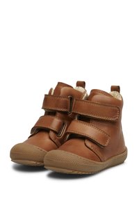 Botas de tobillo de cuero marrón con dos correas de Velcro, suela de goma texturizada, punta redondeada y forro suave. Tacón elevado para mayor soporte.