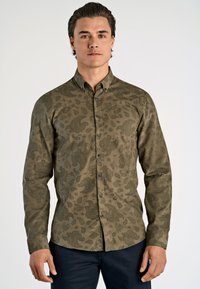 Olijfgroene langekoushemd met een paisleypatroon, overhemdkraag en donkere knopen. Vlotte textuur en aangesloten design.