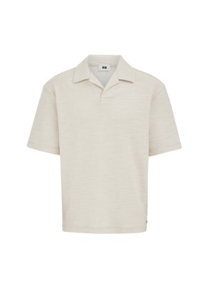 Polo beige de manga corta con tela texturizada y cuello abierto, mostrado sobre un fondo blanco.