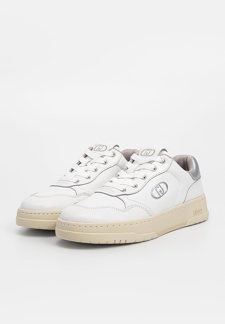 Witte leren sneakers met een ronde vorm, voorzien van een beige zool, zilveren accenten op de hiel en een vetersluiting met logo-detail.