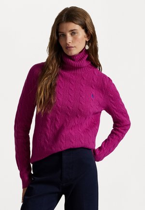 Fuchsia gestrickter Rollkragenpullover mit einem Kabelstrickmuster. Weicher Stoff mit einer lässigen Passform, kombiniert mit dunklen Hosen.
