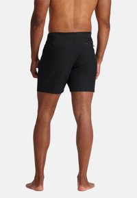 Costumi da bagno neri realizzati in materiale leggero, caratterizzati da una texture liscia e una tasca posteriore discreta per lo stoccaggio.