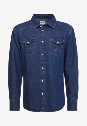 Granatowa denimowa koszula z długimi rękawami, zapinana na zatrzaski, z wraz z modnym kołnierzykiem oraz dwoma kieszeniami na piersi ozdobionymi przeszyciami.