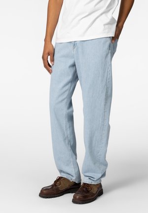 Lys blå denim jeans med avslappet passform, med sidelommer og subtile sømdetaljer, kombinert med brune snøresko.