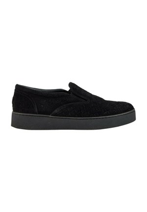 Sort slip-on sneaker med quiltet tekstiloverdel og tekstureret gummisål vist i sideprofil på hvid baggrund.