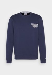 Felpa blu navy realizzata in misto cotone, con collo a giro, maniche lunghe e logo bianco "TOMMY JEANS" sul lato sinistro del petto.