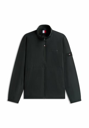 Schwarze Reißverschlussjacke mit hohem Kragen, Seitentaschen und kleinem rot-weiß-blauem Flaggenlogo auf der Brust und am linken Ärmel.