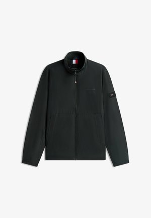 Schwarze Reißverschlussjacke mit hohem Kragen, Seitentaschen und kleinem rot-weiß-blauem Flaggenlogo auf der Brust und am linken Ärmel.